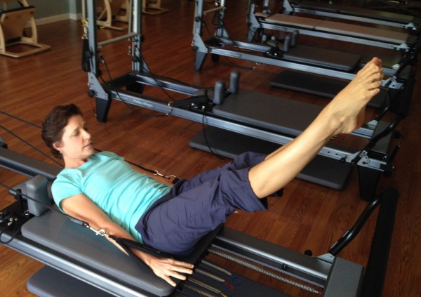 Kelli Loomis demonstrates the use of the reformer at Blue Sky Pilates