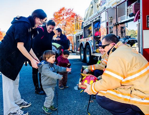 Two year old James Sung dances with delight while meeting Cary Firemen Craig McDowell and Colton (New Guy) Barringer. (The chief jokingly asks for Colton to be called "New Guy" as part of a "fireman hazing thing."