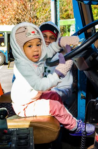 Three year old Coi Reynolds of Durham takes time behind the wheel of the Concrete Supply mixing truck while her father, Sheldon, watches.